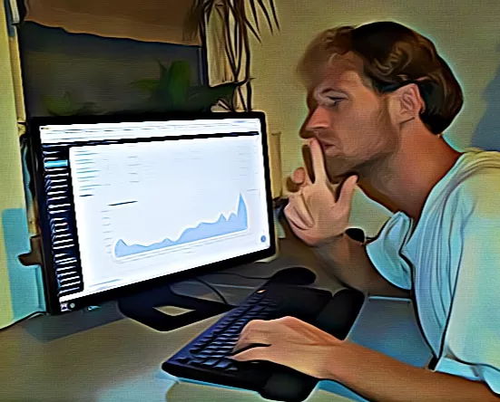 WordPress Entwickler Dominik Späte macht eine Geste des Überlegens vor einem Monitor