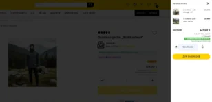 Screenshot eines Gambio-Onlineshops mit der Produktseite der ‚Outdoor-Jacke Wald robust‘. Rechts ist der Mini-Warenkorb geöffnet und zeigt zwei Artikel: 2× ‚Outdoor-Jacke Stuttgart 21‘ (298,00 €) und 1× ‚Outdoor-Jacke Wald robust‘ (129,00 €). Der Gesamtwert beträgt 427,00 €, inklusive 19 % MwSt. in Höhe von 68,18 €. Ein Hinweis informiert über kostenlosen Versand ab 50 €. Eine Warenkorb-Bestätigung mit dem Text ‚Gute Kombi!‘ ist sichtbar, darunter der gelbe Button ‚Zum Warenkorb‘.