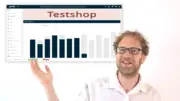 Gambio-Admin mit rotem Banner „Testshop“ über den Shop-Statistiken, davor eine gestikulierende Person